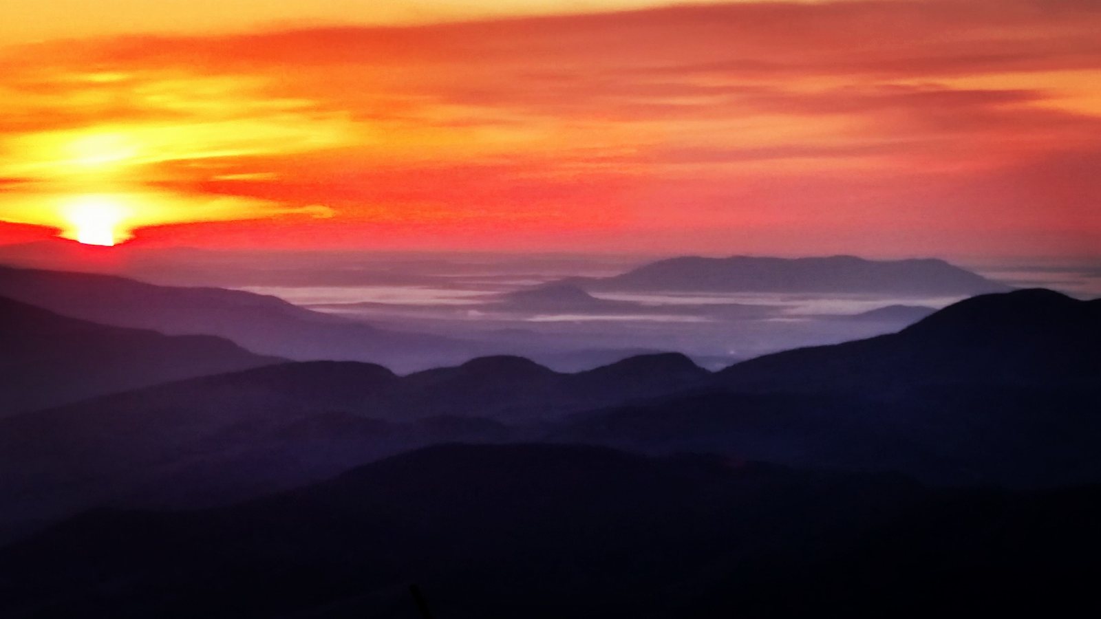 The sun rising over layers of White Mountains ridges from a 4000-foot summit